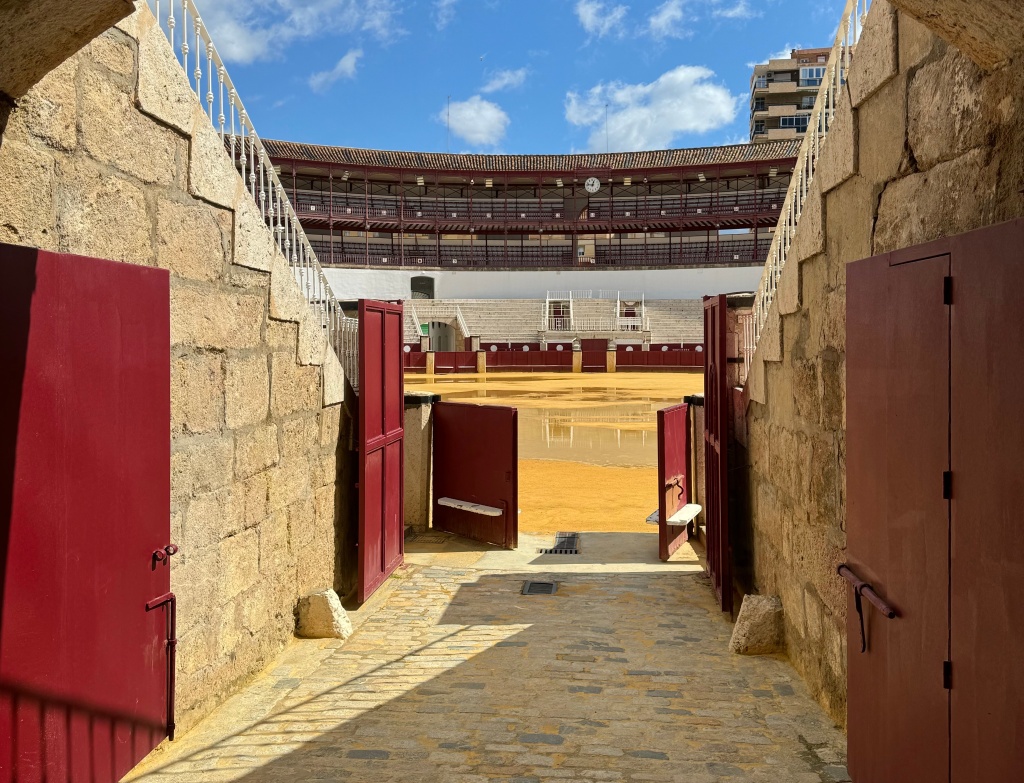 View through a red doorway to an empty bullfighting ring