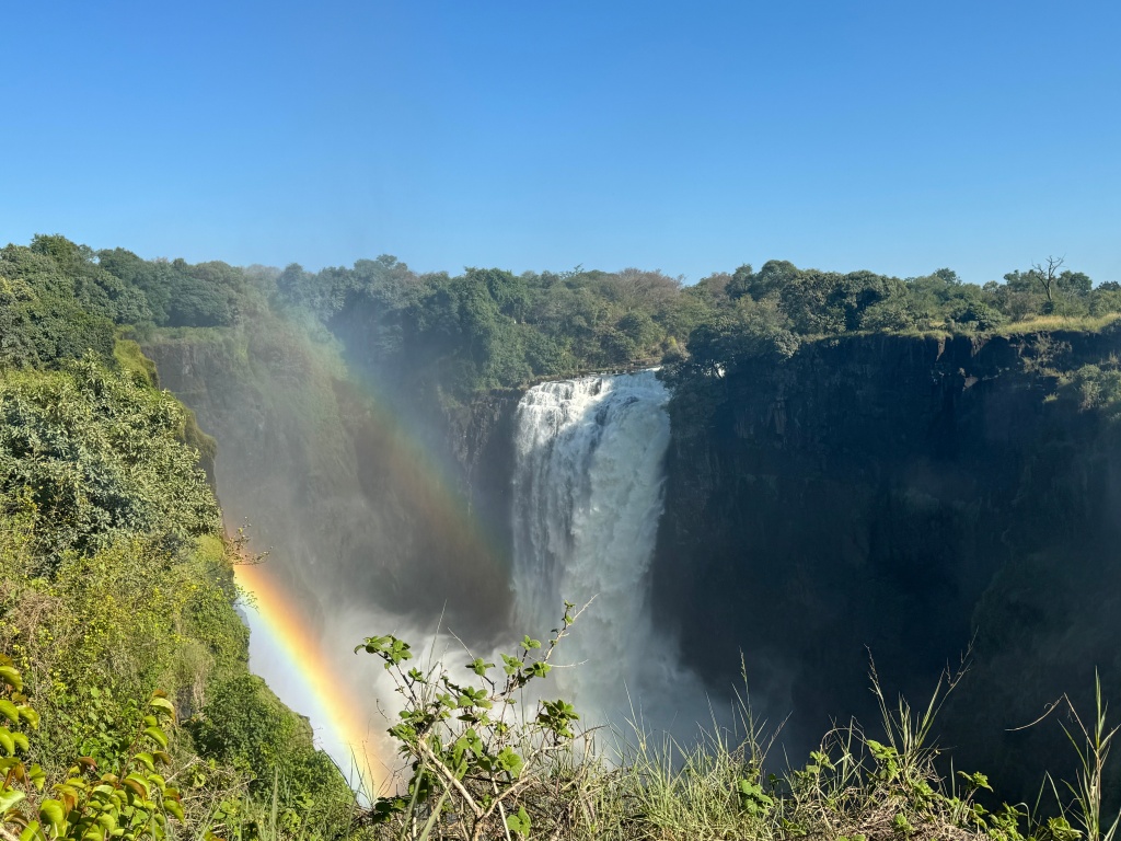A powerful waterfall (Victoria Falls) with a double rainbow in the spray.